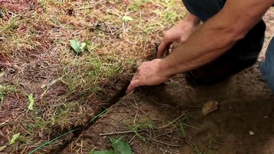 Dog fence wire being placed in a small trench