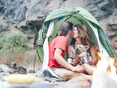 couple camping with a small dog