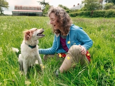 lady and dog sitting in the grass